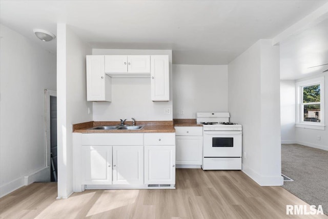 kitchen with light hardwood / wood-style floors, white range, sink, and white cabinets