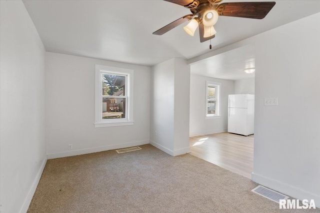 empty room with ceiling fan and light colored carpet