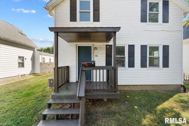 view of front of house with a front yard and central AC unit