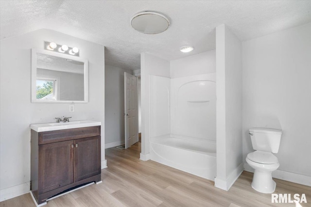 full bathroom featuring a textured ceiling, wood-type flooring, vanity, and toilet