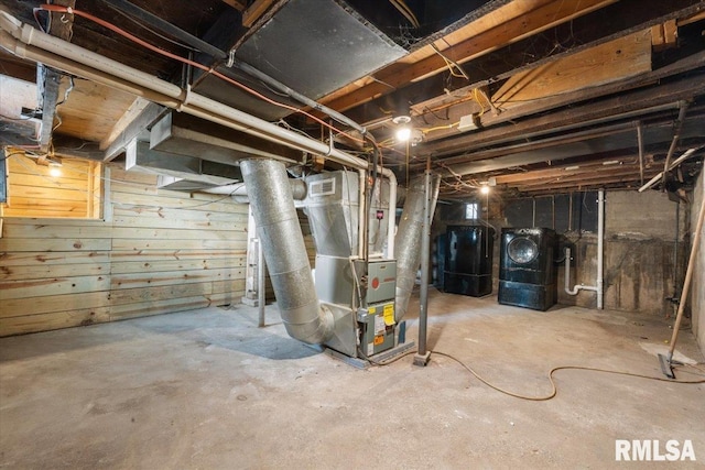 basement featuring wood walls and heating unit