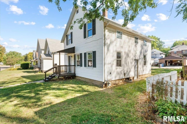 rear view of house featuring a lawn