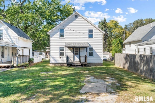 rear view of house featuring a lawn