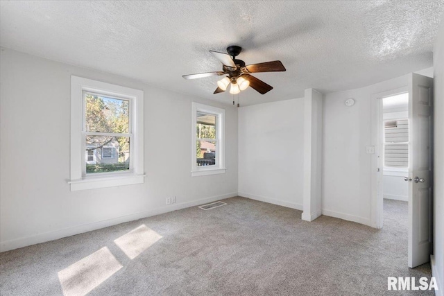 unfurnished room with ceiling fan, light colored carpet, and a textured ceiling