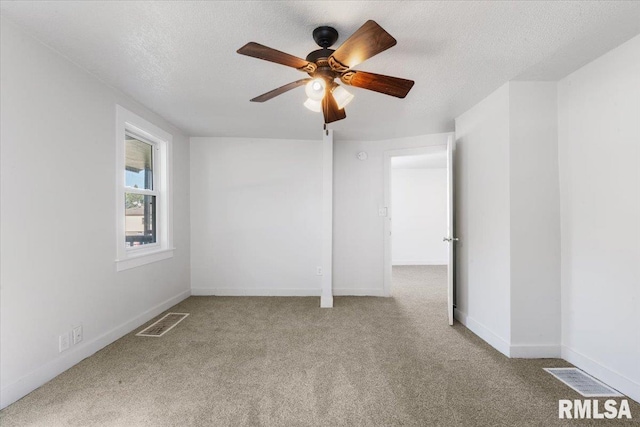 spare room featuring a textured ceiling, carpet floors, and ceiling fan