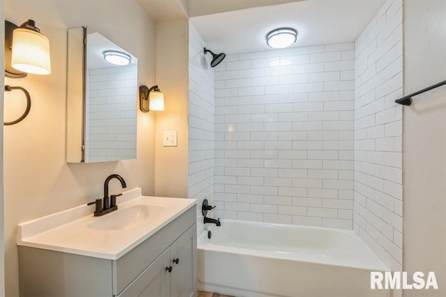 bathroom with tiled shower / bath and vanity