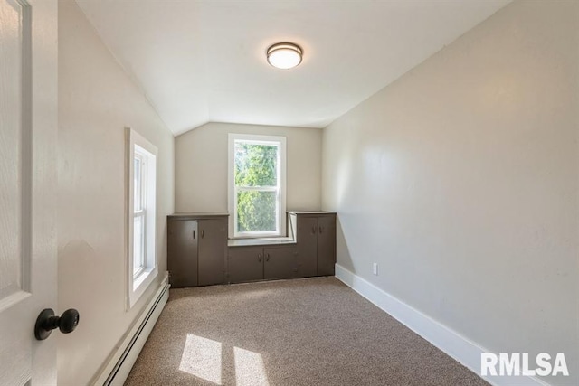 spare room featuring baseboard heating, vaulted ceiling, and carpet