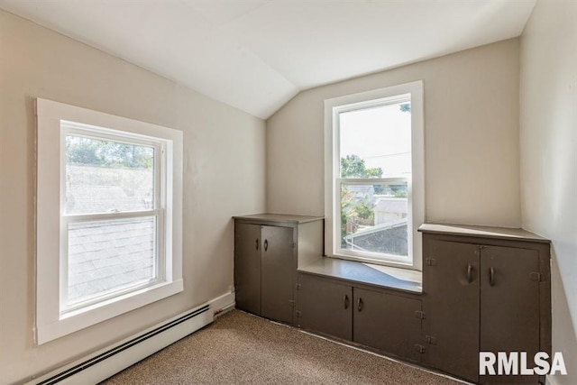 additional living space with light carpet, a baseboard radiator, and vaulted ceiling