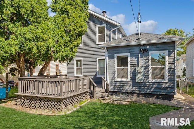 back of house with a deck and a yard