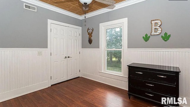 bedroom with a closet, dark hardwood / wood-style floors, ornamental molding, and wooden ceiling