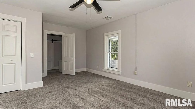 unfurnished bedroom featuring ceiling fan, carpet flooring, baseboards, and visible vents