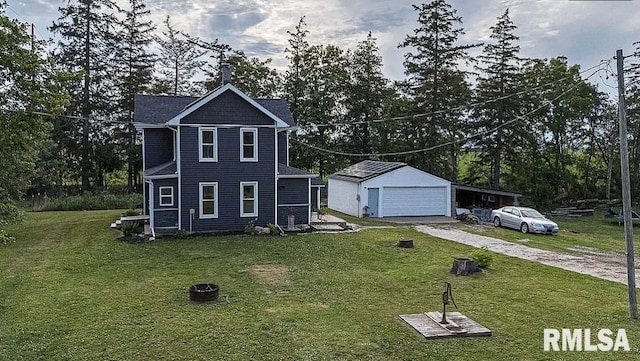 view of front of property featuring a garage, a front lawn, and an outbuilding