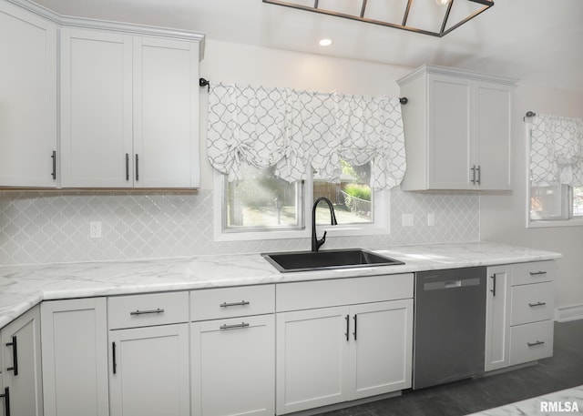 kitchen featuring dishwasher, light stone counters, white cabinetry, and sink