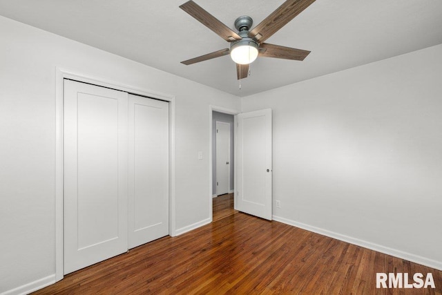 unfurnished bedroom featuring ceiling fan, a closet, and dark wood-type flooring