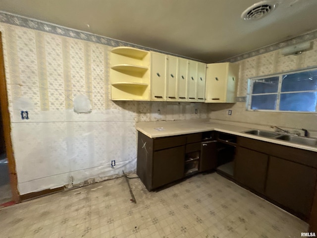 kitchen featuring dark brown cabinets, cream cabinetry, and sink