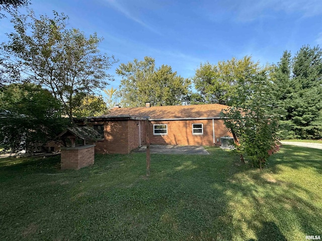 back of property featuring central AC unit and a yard