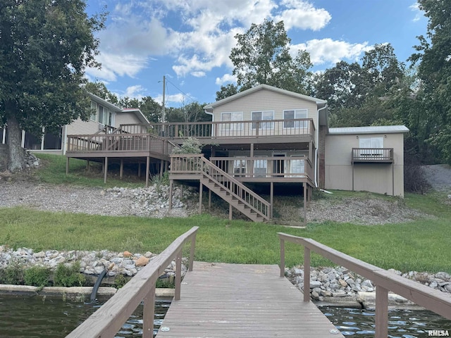 back of house featuring a lawn and a deck with water view