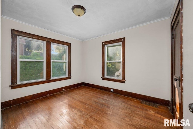 spare room featuring dark wood-type flooring and crown molding