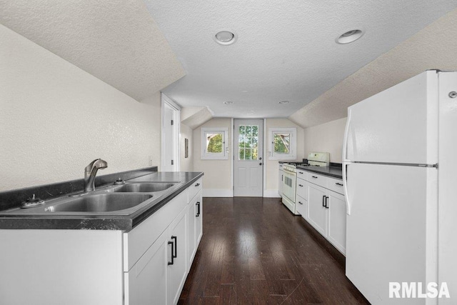 kitchen featuring white cabinets, lofted ceiling, dark hardwood / wood-style floors, and white appliances