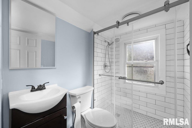 bathroom with a shower with shower door, vanity, and toilet