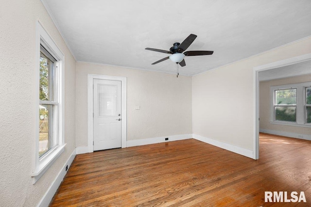 unfurnished room with ceiling fan, dark hardwood / wood-style floors, ornamental molding, and a healthy amount of sunlight