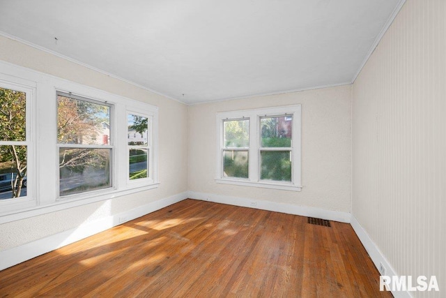 unfurnished room featuring crown molding and hardwood / wood-style floors