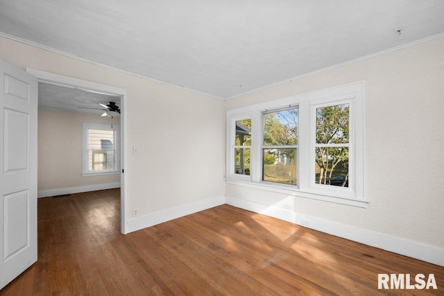 unfurnished room with dark hardwood / wood-style floors, ornamental molding, a wealth of natural light, and ceiling fan