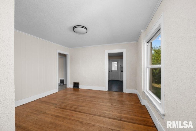 unfurnished room featuring hardwood / wood-style flooring and crown molding