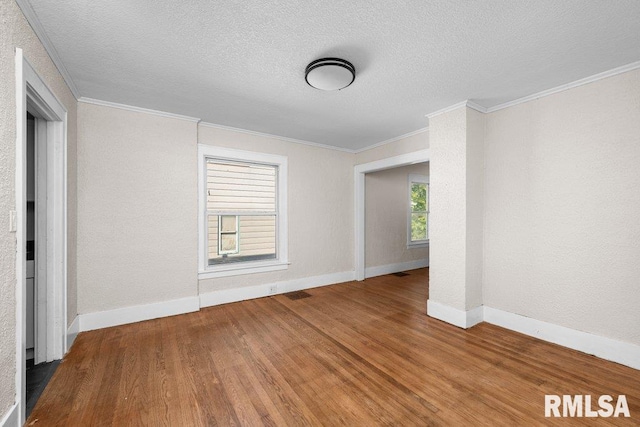 unfurnished room with wood-type flooring, crown molding, and a textured ceiling