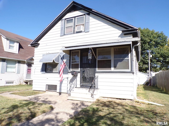 bungalow-style house featuring cooling unit and a front yard