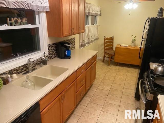 kitchen featuring tasteful backsplash, light tile patterned floors, black appliances, ceiling fan, and sink