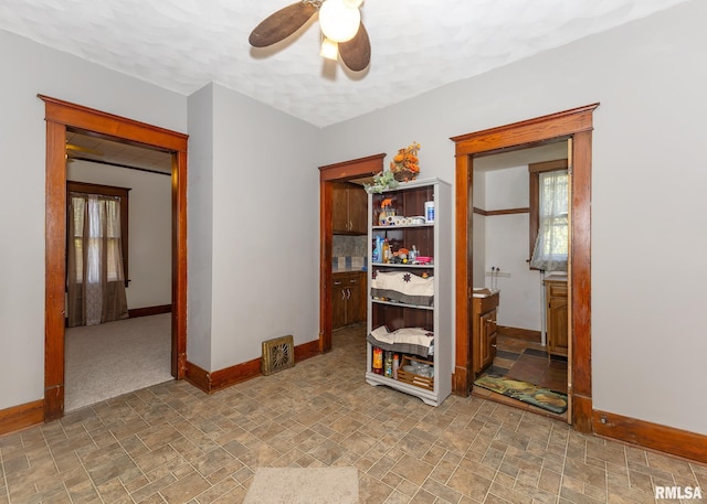 interior space with ceiling fan