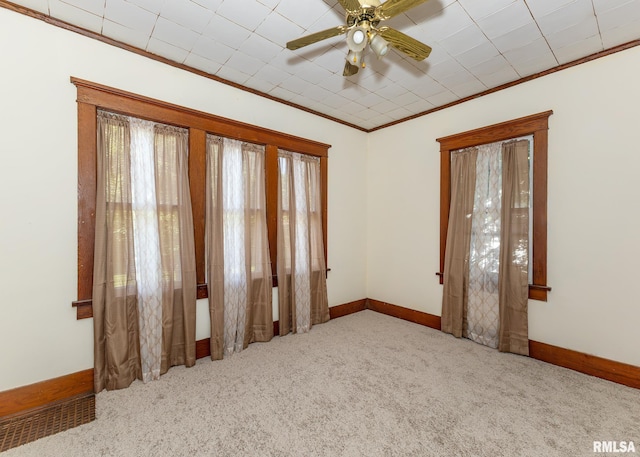 carpeted spare room with crown molding and ceiling fan