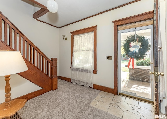 entrance foyer with crown molding and light colored carpet