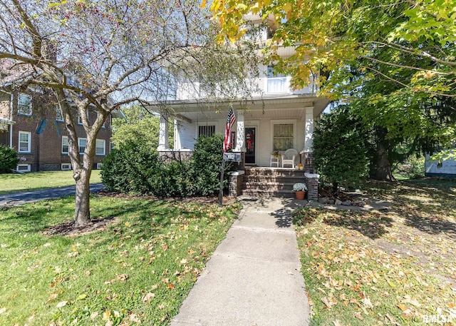 view of front of home with a front yard and covered porch