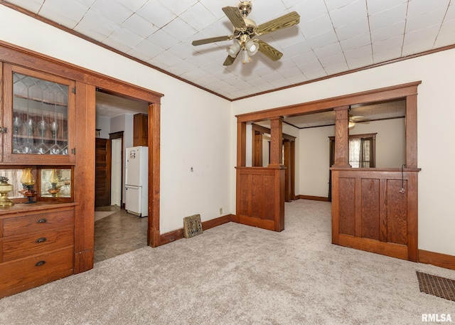 carpeted spare room with ornamental molding and ceiling fan