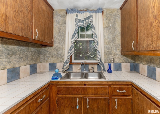 kitchen featuring tile countertops, sink, and decorative backsplash