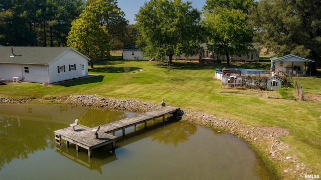 view of dock with a lawn and a water view