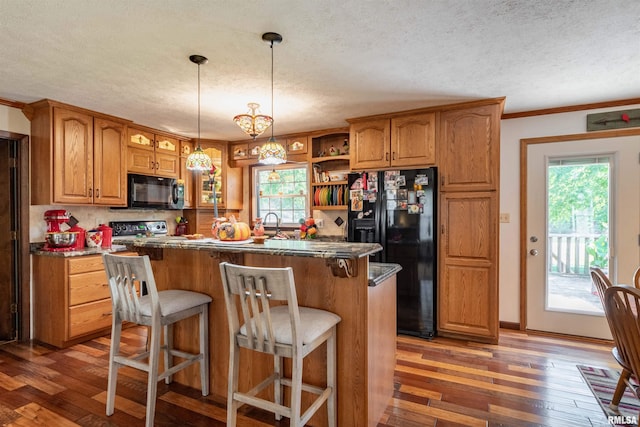 kitchen featuring a wealth of natural light, black appliances, dark wood-type flooring, and a kitchen island