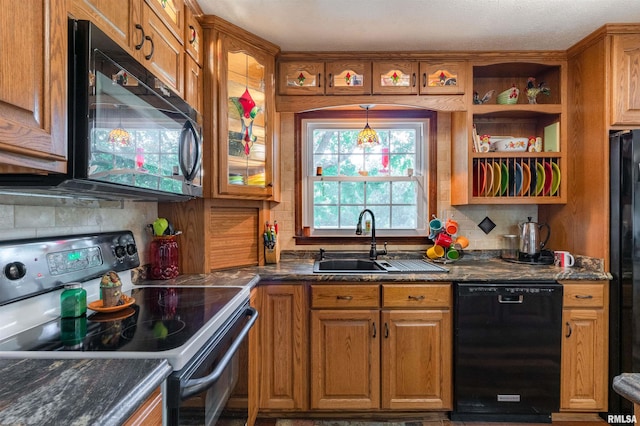 kitchen featuring decorative backsplash, black appliances, dark stone counters, and sink