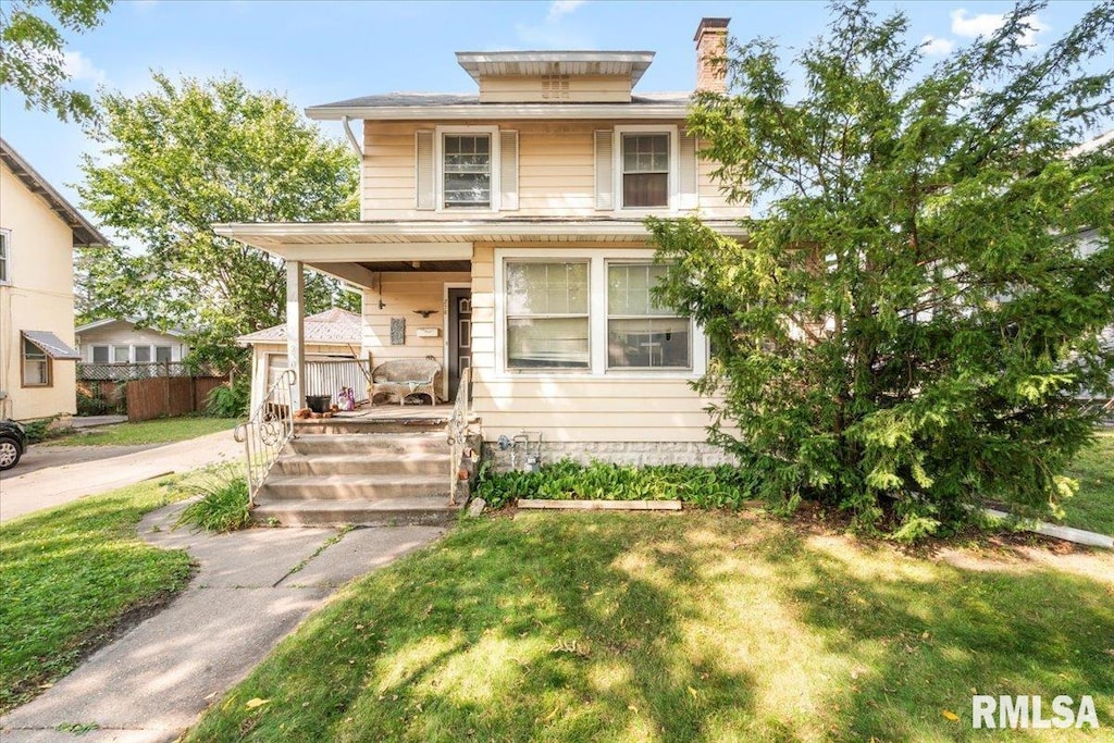 view of front facade with covered porch and a front yard