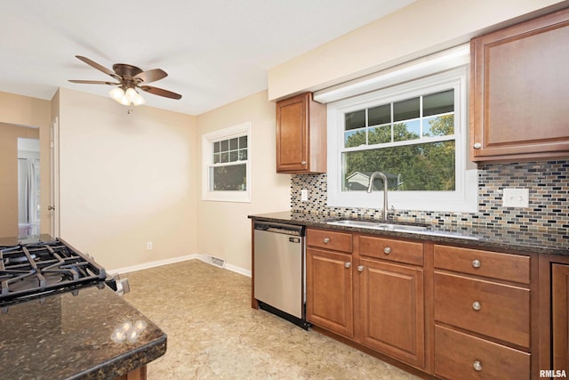 kitchen featuring ceiling fan, sink, tasteful backsplash, dishwasher, and dark stone counters