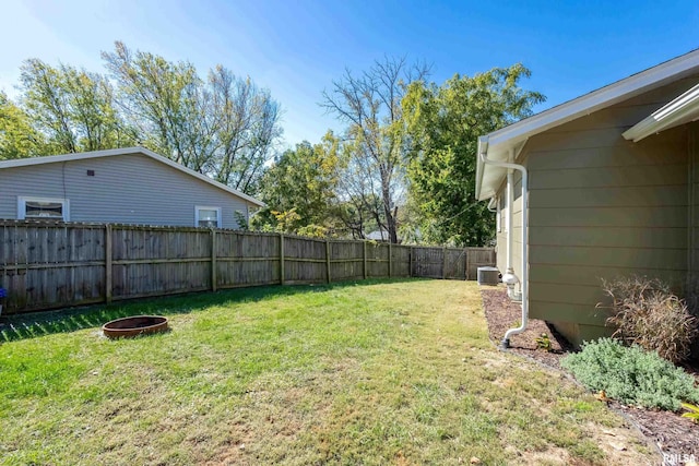 view of yard with a fire pit and central AC unit