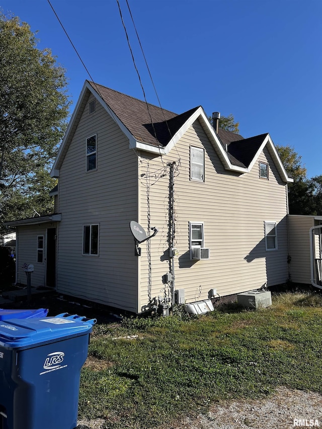 view of side of property with a yard and cooling unit