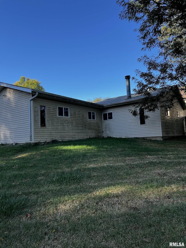 rear view of property featuring a lawn