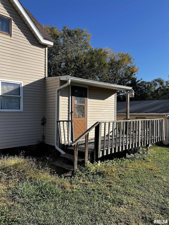 view of exterior entry featuring a lawn