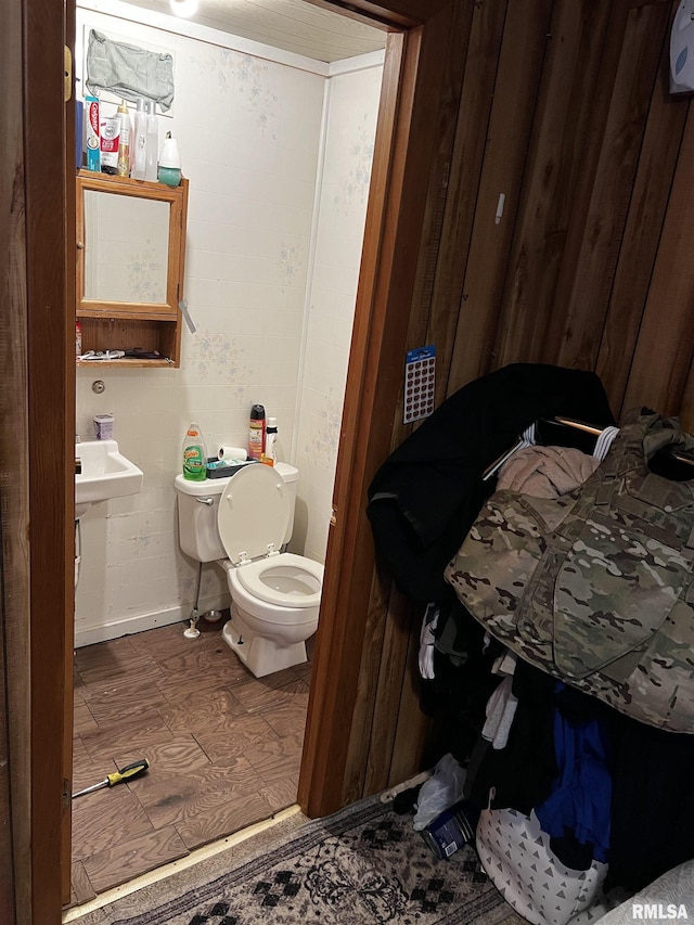 bathroom featuring toilet, baseboards, and wood finished floors