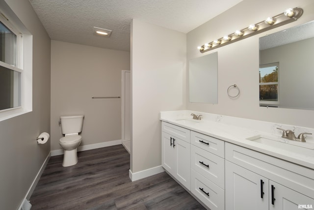 bathroom featuring a textured ceiling, wood-type flooring, vanity, and toilet