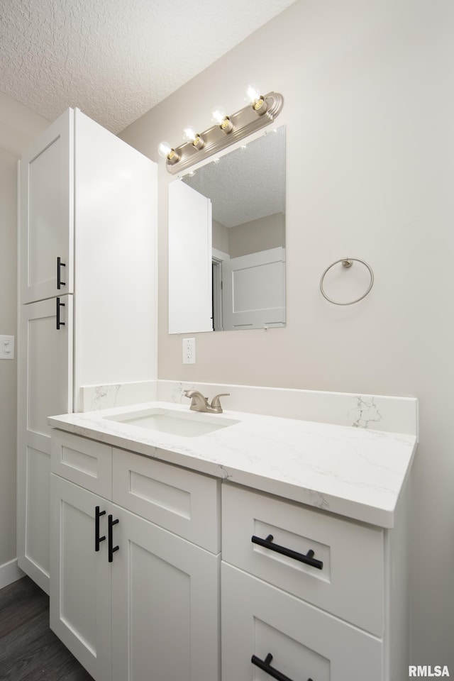 bathroom with vanity, hardwood / wood-style floors, and a textured ceiling