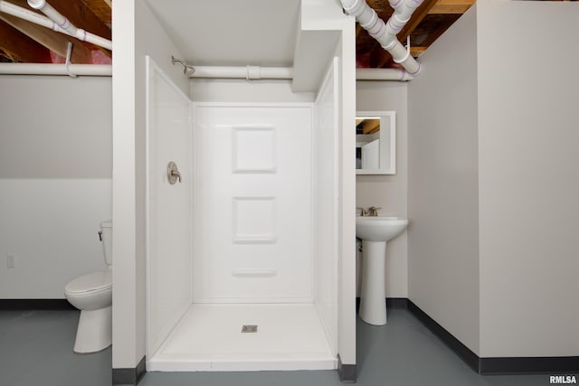 bathroom with walk in shower, toilet, and concrete floors